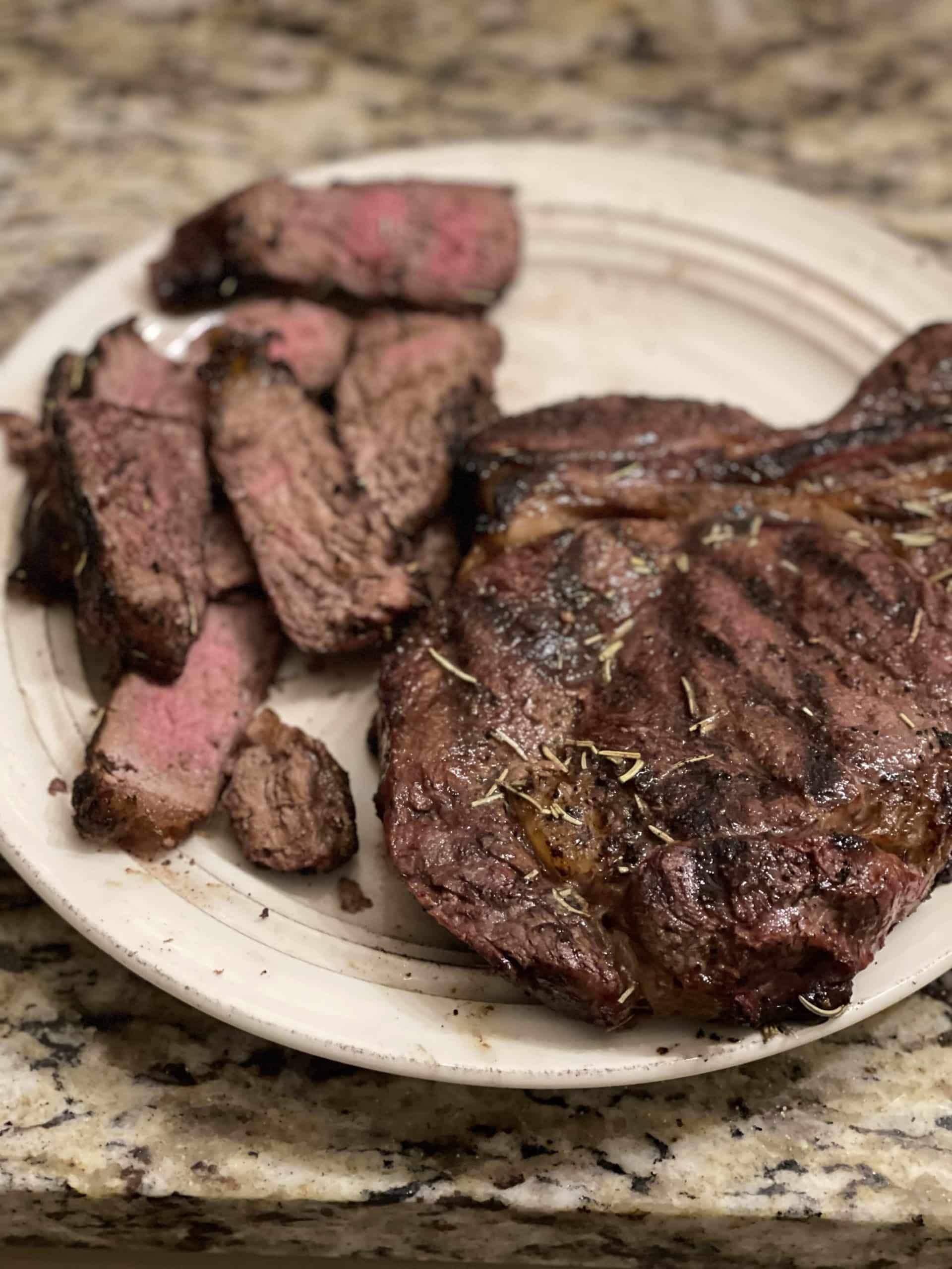 A close up image of steak sliced on a plate.